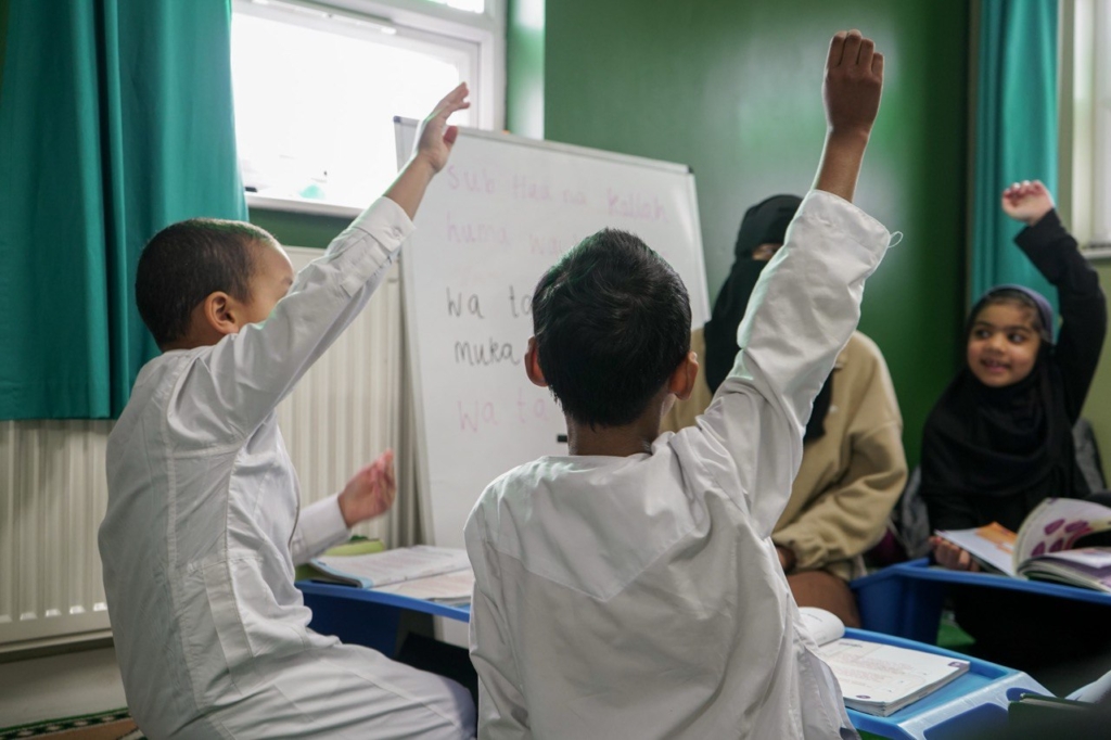 Madrasah classroom with low wooden desks and bookshelves